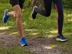 Two runners wearing Crivit running shoes jog on a trail.
