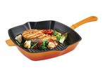Grilled salmon and vegetables in an orange cast iron grill pan.