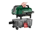 A person's hand holding the green top part of a wet and dry vacuum cleaner over its clear wheeled base.