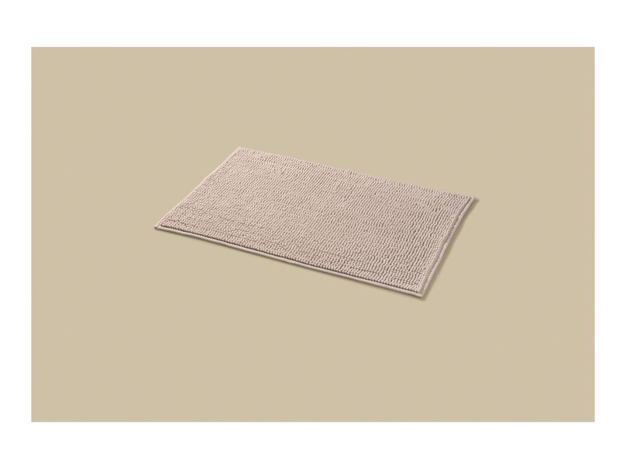 A light beige rectangular bath mat with a textured, looped pile on a matching background.