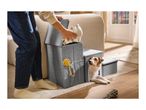 Grey fabric pet stairs with built-in storage compartments and a small dog looking out.