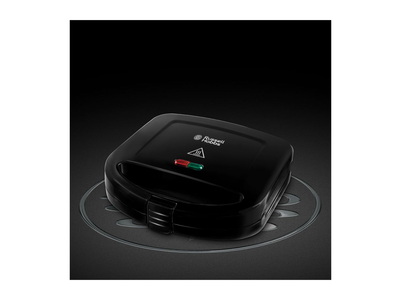 Black sandwich maker with indicator lights on a dark textured surface.