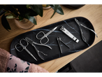 Manicure and pedicure accessories, including nail clippers with 'Cien BEAUTY' branding, on a black marble tray.