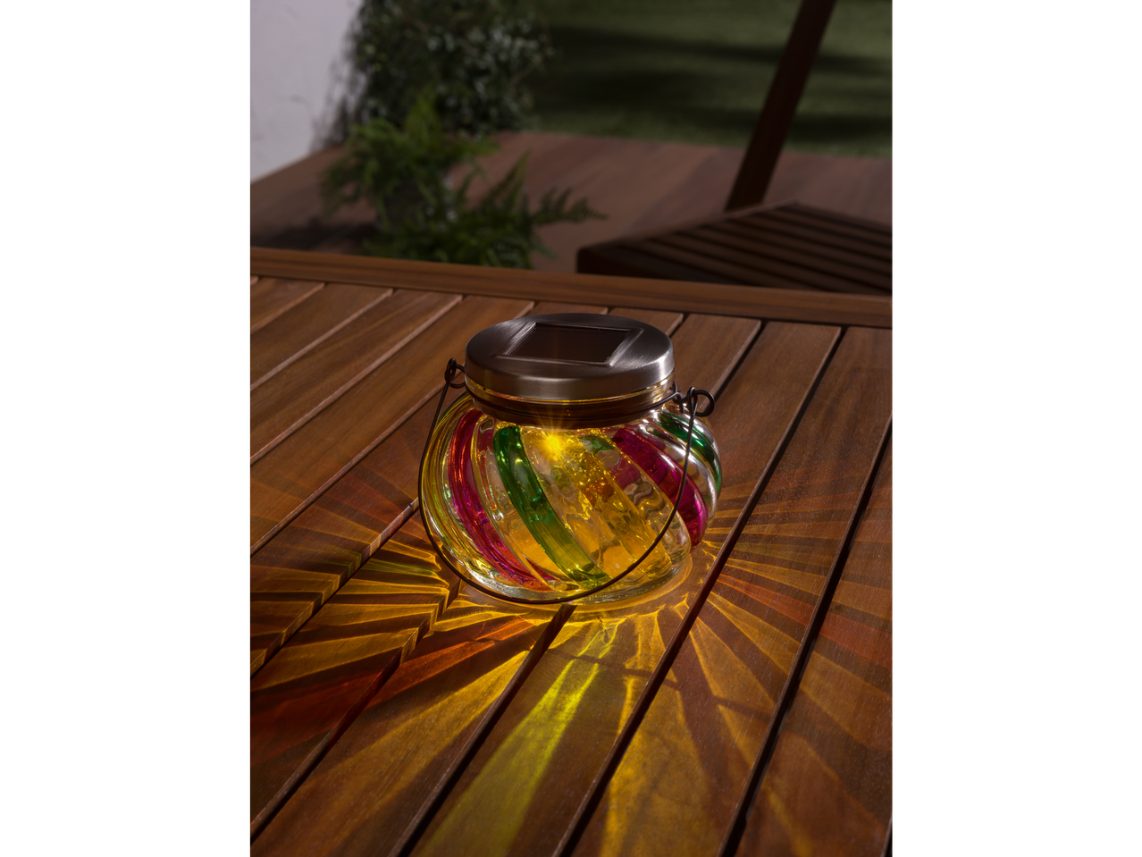 Luminária solar em forma de frasco em uma mesa de madeira.
