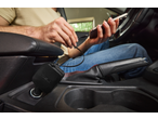 Man laadt een smartphone op in een auto met een autolader.