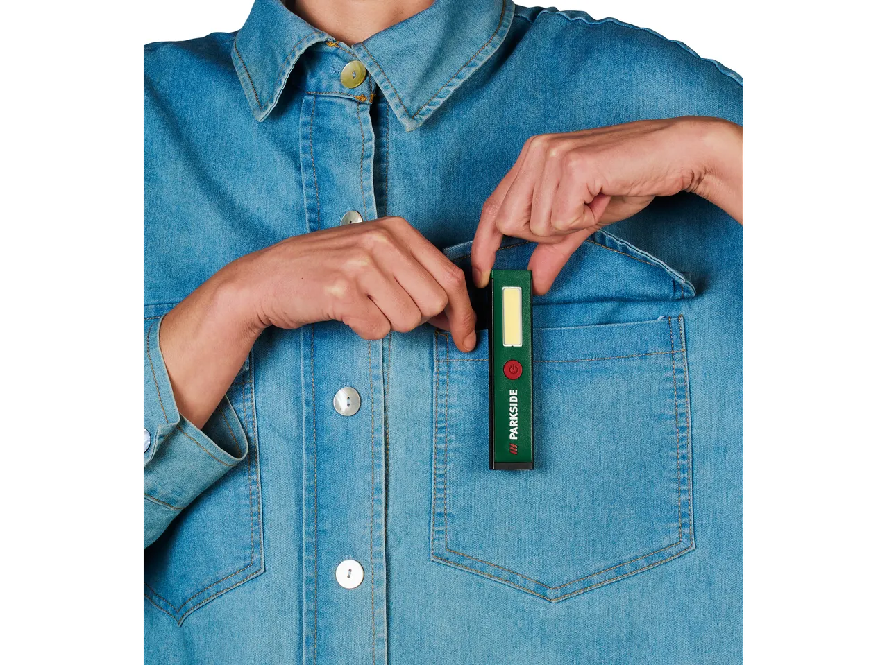 Osoba u teksas košulji stavlja Parkside® mini-punjivu ručnu lampu u džep.