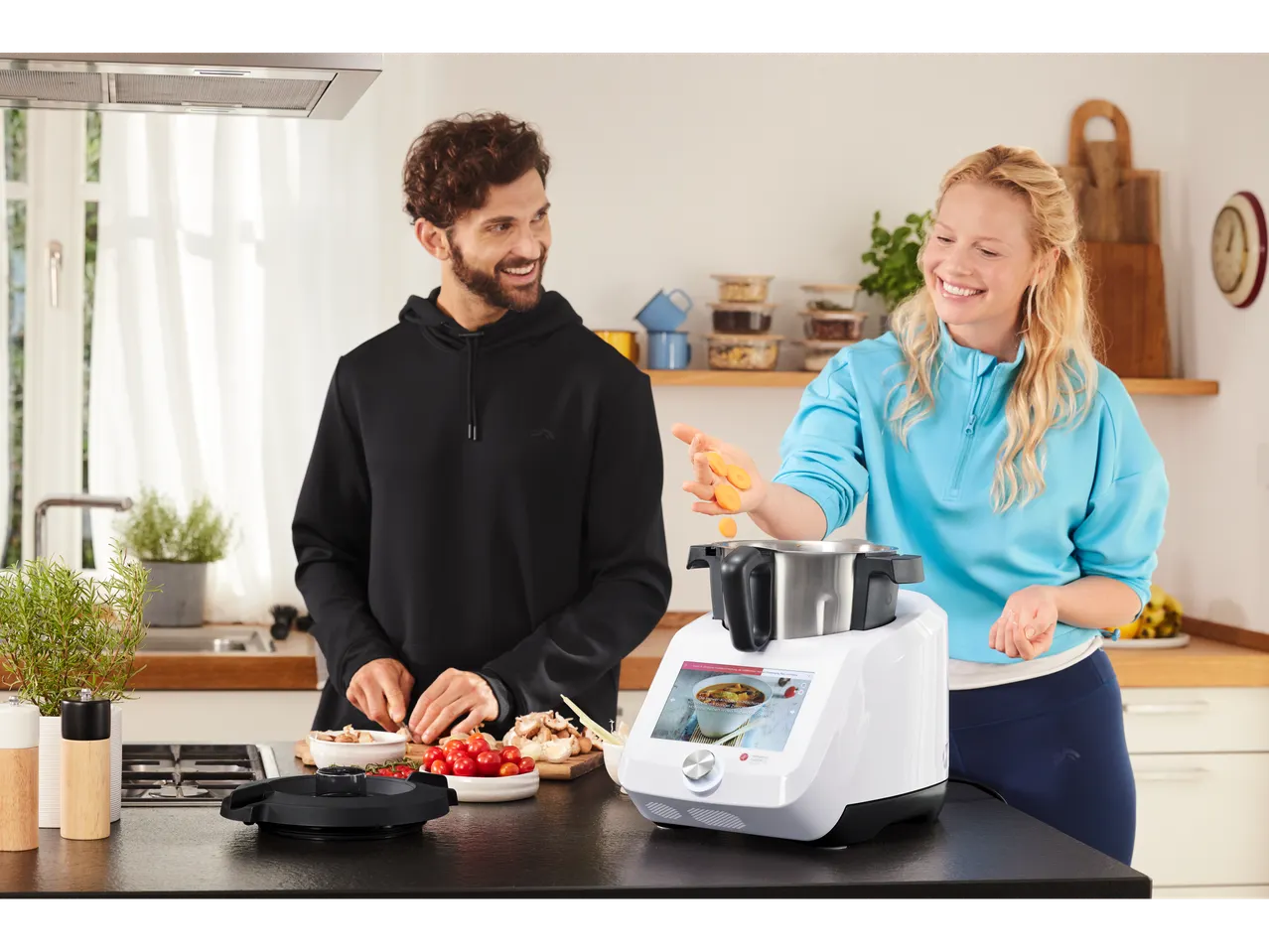Cuplu gătește cu un multicooker în bucătărie.