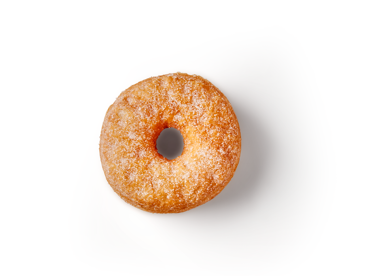 Ein einziger, zuckerüberzogener Donut liegt auf weißem Hintergrund.