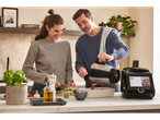 Cuplu gătind în bucătărie cu un robot de bucătărie și legume proaspete.