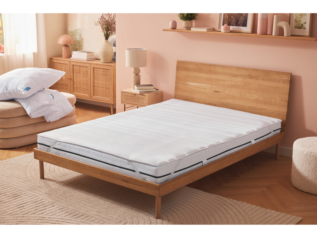 Mattress topper and pillows on a wooden bed.