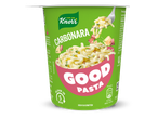 Een groene cup met pasta carbonara, klaar in 5 minuten, met een vork vol pasta en spekjes.