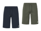 Zwei New Balance Shorts in Dunkelblau und Olivgrün.