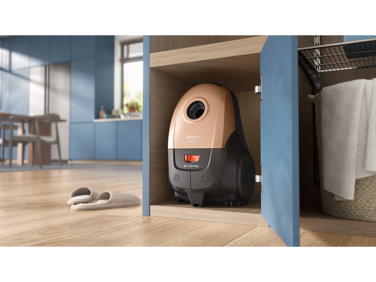 Vacuum cleaner stored in a wooden cabinet, with slippers on a wooden floor in a modern kitchen.