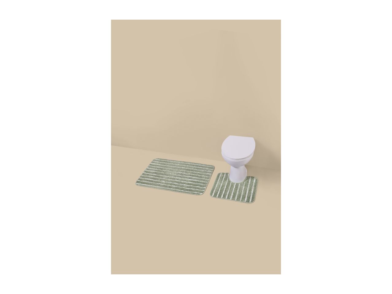 Two green striped bath mats on a beige floor in front of a white toilet.