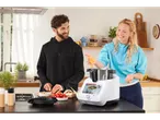 Cuplu gătește cu un multicooker în bucătărie.