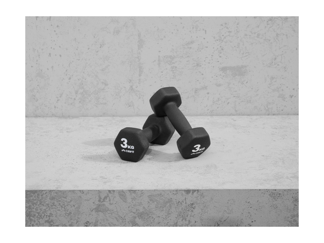 Two black 3kg Crivit dumbbells on a concrete surface.