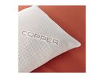 A white pillow with the word 'COPPER' embroidered on it, resting on a rust-colored surface.
