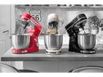 Three stand mixers in red, cream, and black on a kitchen counter with a Route 66 sign.