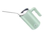 Light green milk frother with a spoon of foam being scooped out, on a white background.