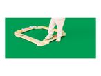 Child's legs on a wooden balance beam with colorful stepping stones on a green background.