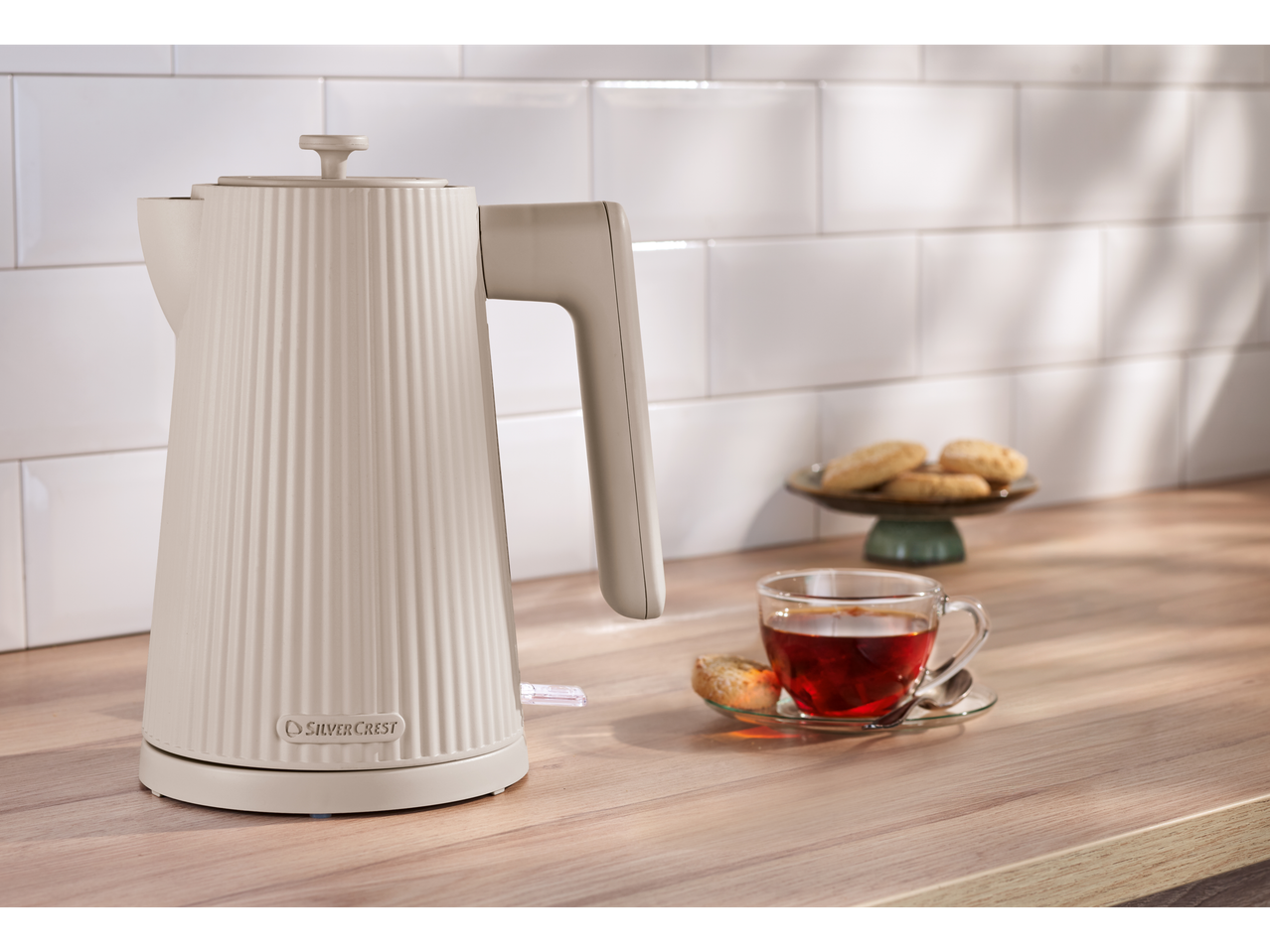 SILVERCREST® 3000W Kettle in cream, with tea and cookies on a wooden counter.