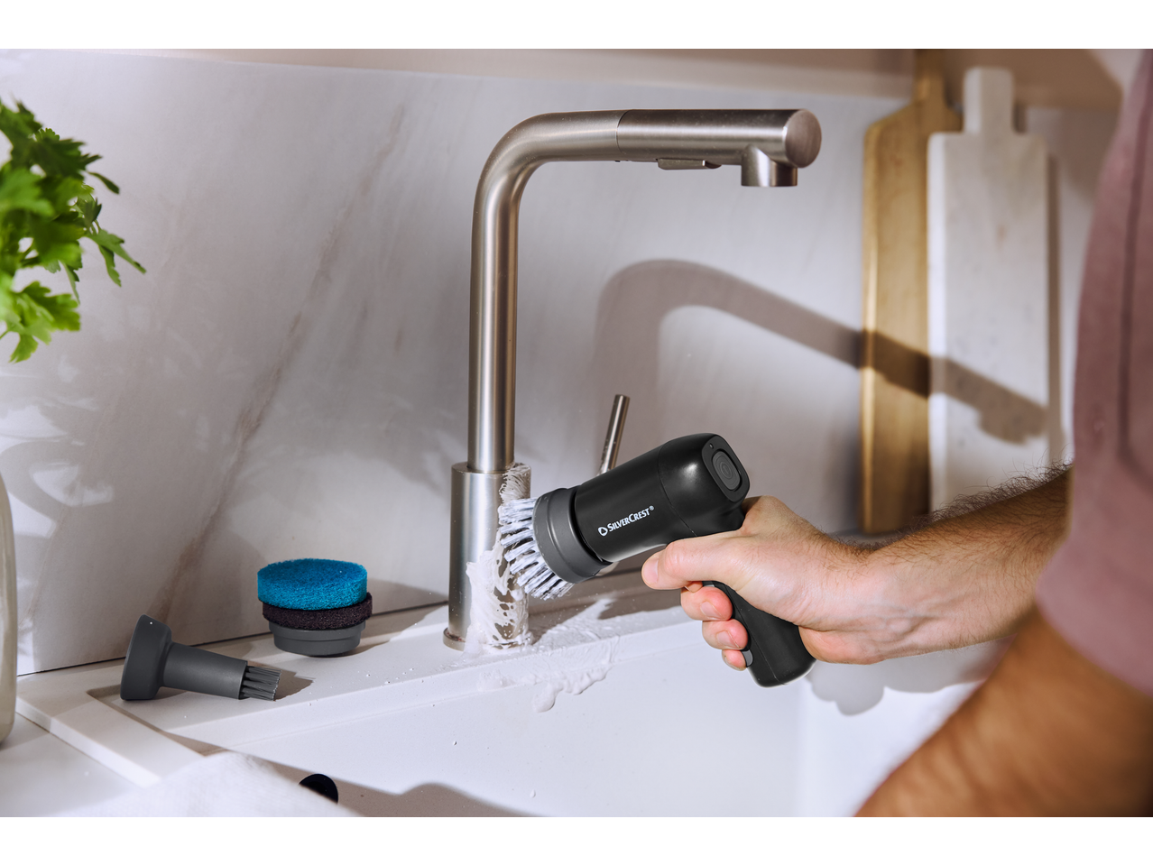 Escova de limpeza elétrica SILVERCREST a limpar uma torneira de cozinha