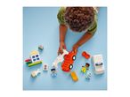 Overhead view of a child playing with colorful building blocks, including a car, house, and figures.