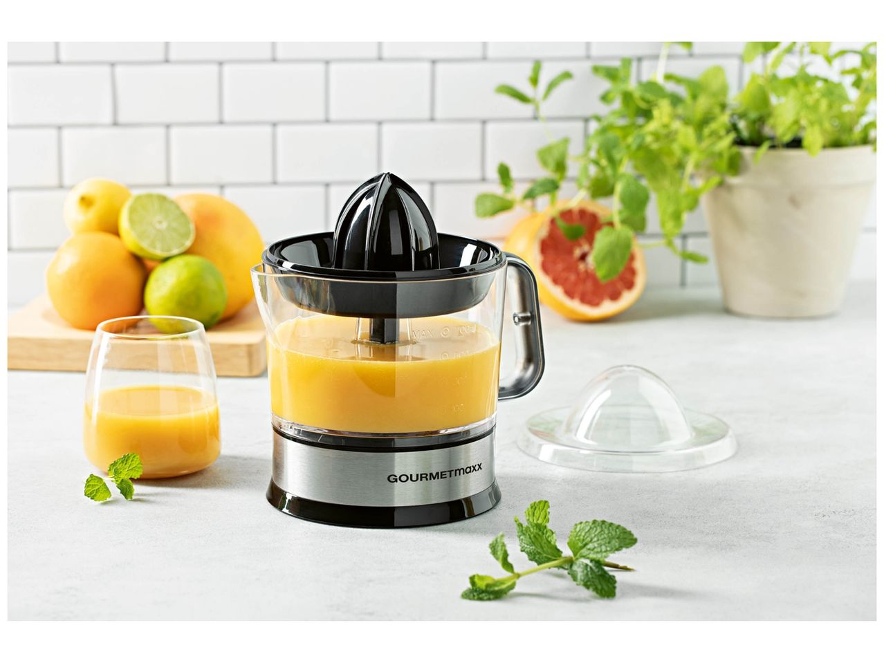 Presse-agrumes électrique GOURMETmaxx avec jus d'orange, agrumes et menthe.