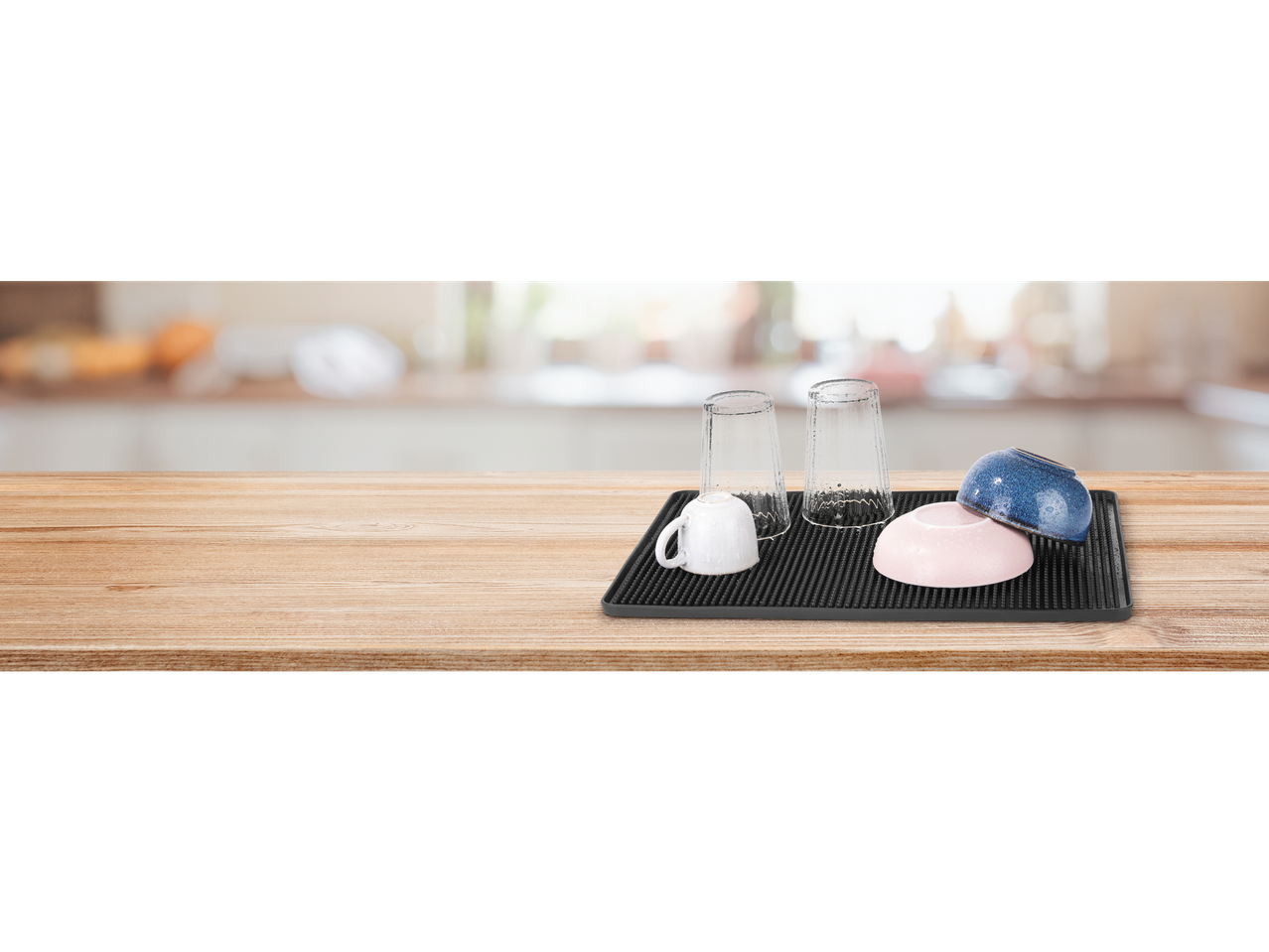 Tapis égouttoir Silvercrest® com pratos e copos numa mesa de madeira na cozinha.