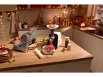 Meat grinder and bread slicer on a kitchen counter decorated for Christmas.