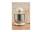 Cream-colored stand mixer with a stainless steel bowl on a wooden countertop