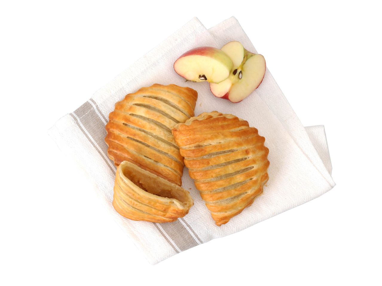 Chaussons aux pommes dorés sur une serviette blanche avec des tranches de pomme.