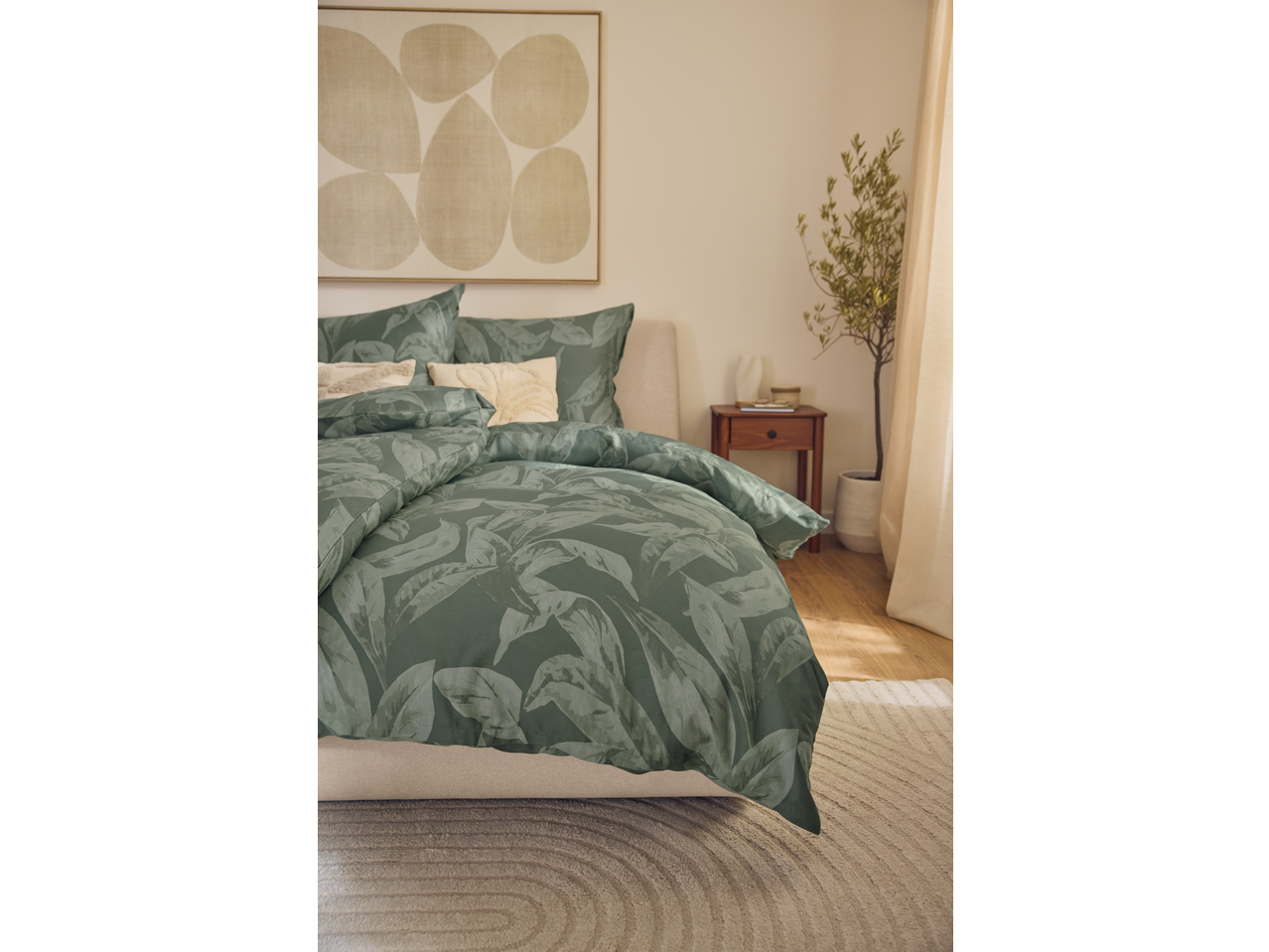 Livarno Home Sateen Duvet Cover Set with green leaf pattern on a bed in a bright room.