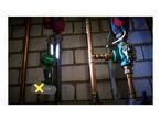 A Parkside work light illuminates pipes and a Vaillant pump in a basement.