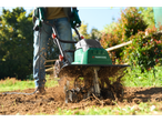 Градински култиватор Parkside® в действие, обработва почвата в градина.
