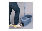 Person in jeans and sneakers using a foot pedal on a spin mop bucket.