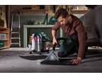 Man cleaning a car mat with a Parkside® 1600W Carpet Cleaner in a garage.