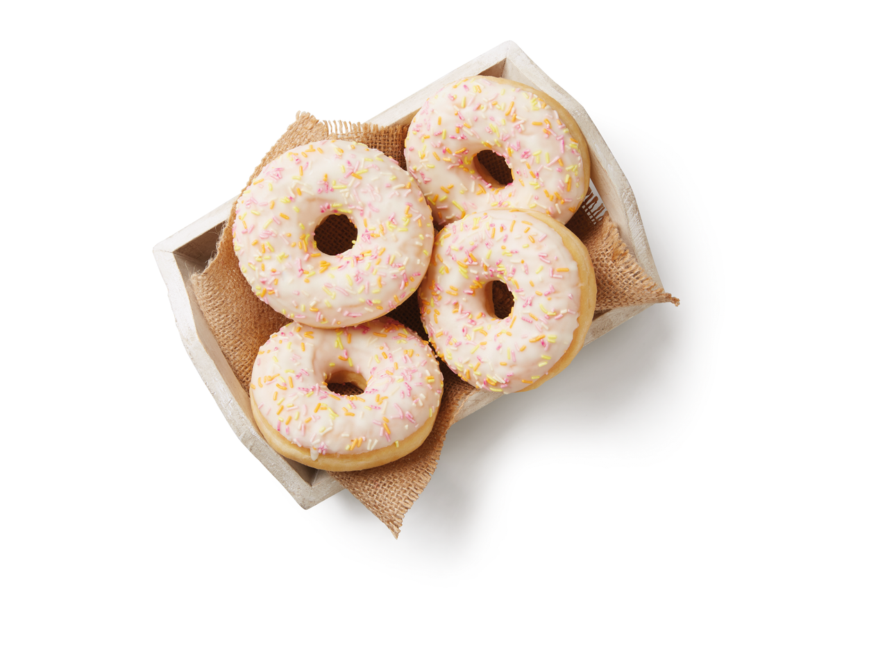 Vier roze donuts met spikkels in een houten bakje.