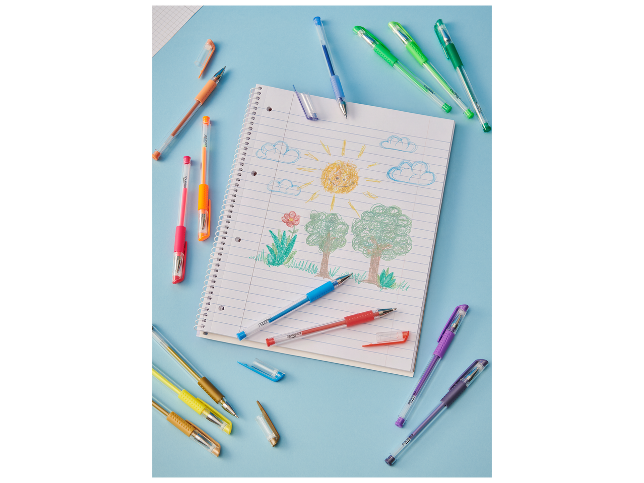Stylos gel colorés et carnet de croquis avec un dessin d'enfant sur fond bleu.