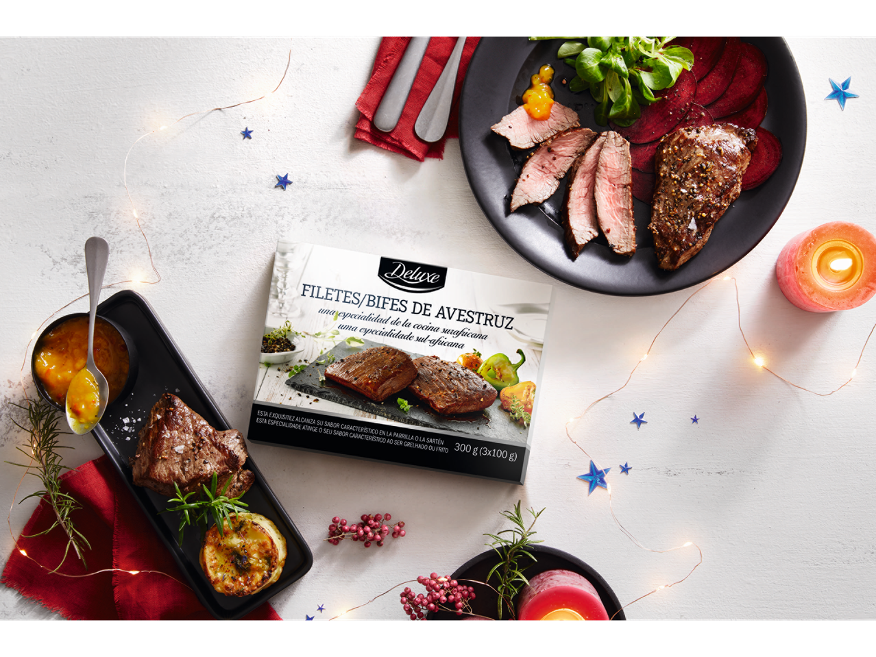 Filetes de avestruz Deluxe com acompanhamentos e decoração numa mesa branca.