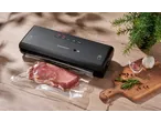 SILVERCREST® Vacuum Sealer with meat in a vacuum bag, garlic, and rosemary on a wooden board.
