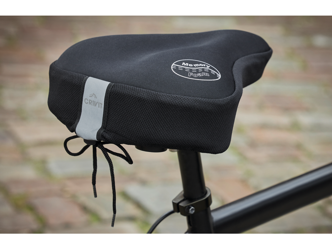 Black bicycle saddle cover with 'Memory Foam' text and reflective strip, on a bike.