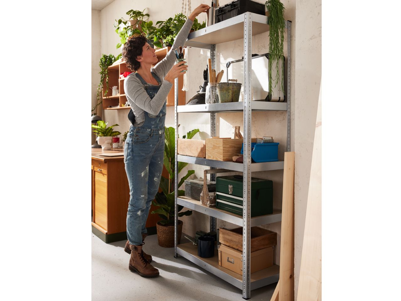 Woman organizing items on a five-shelf metal shelving unit.