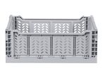 Light grey foldable plastic storage crate with perforated sides, front view.
