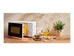 A white microwave with an open door next to a bowl of soup, bread, olive oil, and a potted plant.