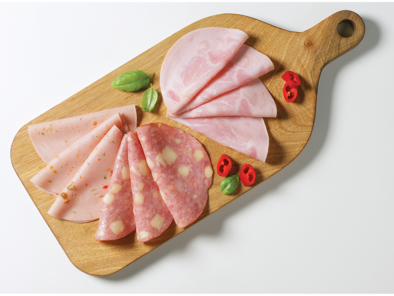 Šunka, mortadela in salama na lesenem desku.