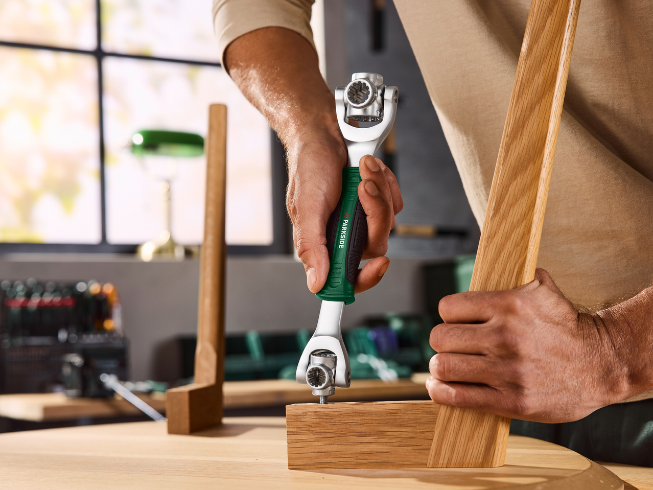 Мъж завинтва дървена част с универсален ключ.