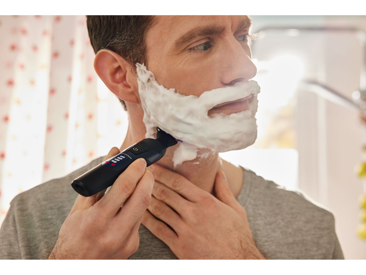 Un uomo si rade la barba con un Regolabarba a lama singola SILVERCREST® PERSONAL CARE.