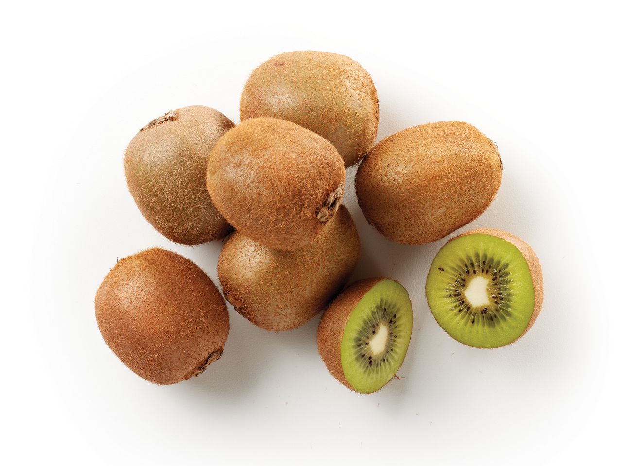Un mucchio di kiwi interi e tagliati a metà su uno sfondo bianco.