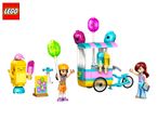 Toy ice cream cart with two figures, a smiling ice cream cone, and a sign.